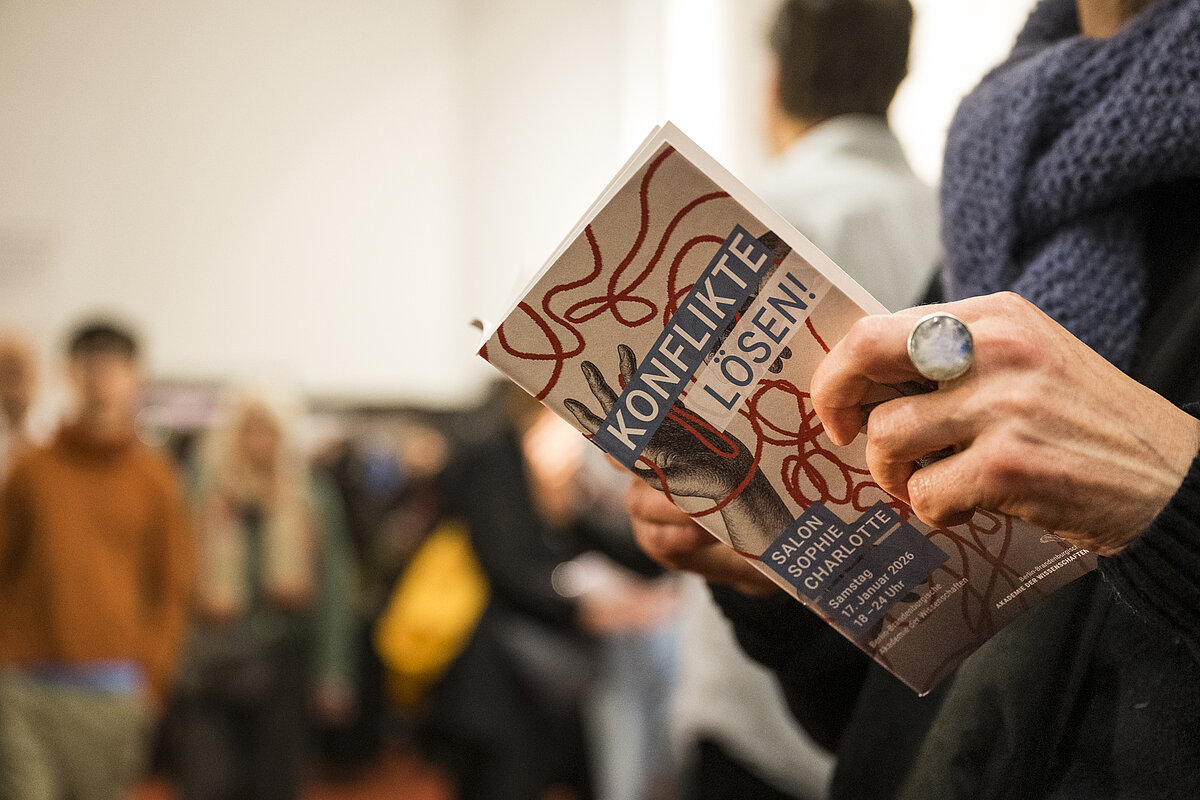 Nahaufnahme von einer Person, die durch das Programmheft blättert