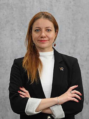 Portrait of Alina Nychyk wearing a black blazer and crossing her arms
