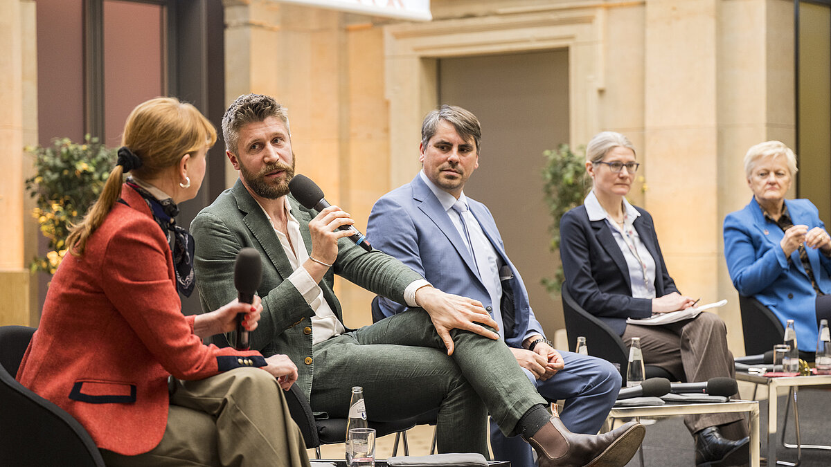 Foto von Renate Künast (Bundesministerin a.D.), Hermine Mitter (Die Junge Akademie), Robert Arlinghaus (Leibniz-Institut für Gewässerökologie und Binnenfischerei) und Benedikt Bösel (Gründer von Gut & Bösel) im Gespräch mit Susanne Götze.