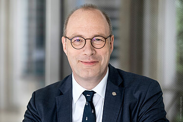 Porträtfoto von Christoph Markschies mit Anzug im Leibniz-Saal