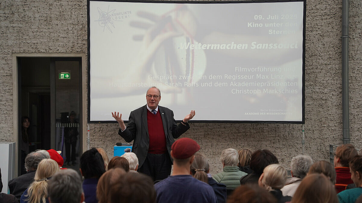 Christoph Markschies spricht vor der gespannten Leinwand zum Publikum